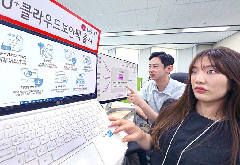 U+ 클라우드보안팩 출시 이미지가 붙은 노트북을 보고 있는 한 여성과 남성의 모습