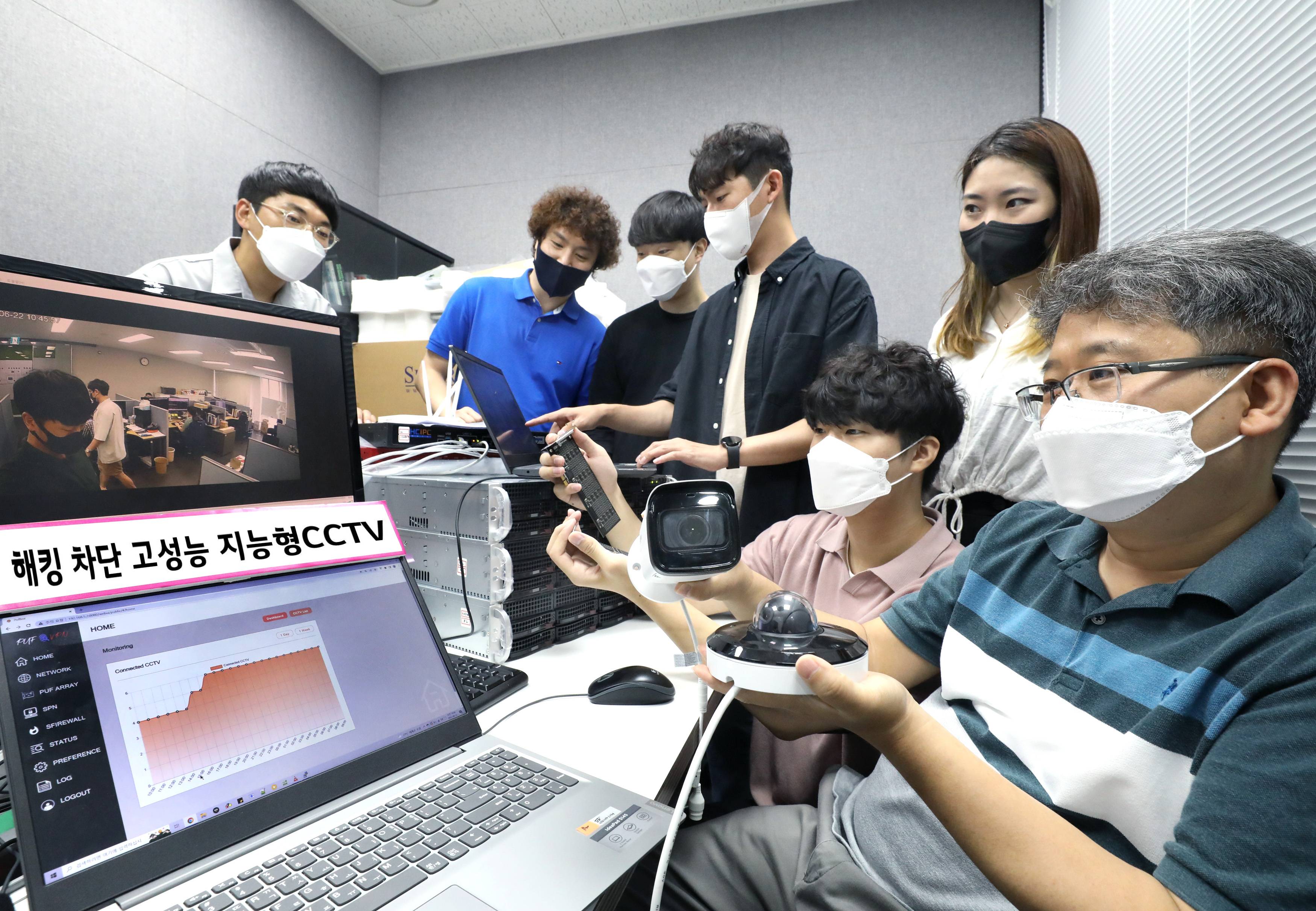 해킹 차단 고성능 지능형 CCTV 이미지가 노출되는 노트북 앞에서 CCTV를 들고 있는 한 남성과 여섯 명의 사람들의 모습