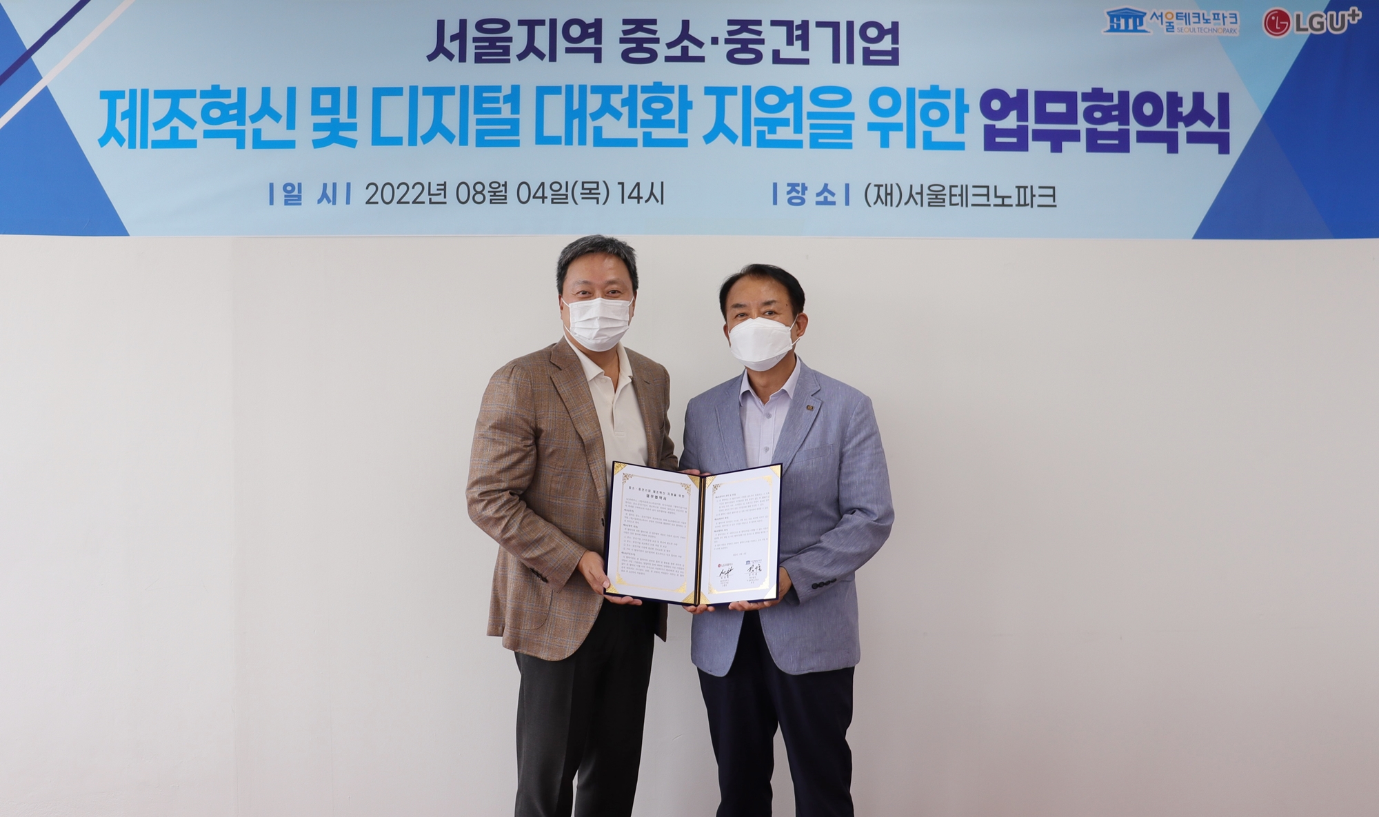 서울지역 중소,중견기업 제조혁신 및 디지털 대전환 지원을 위한 업무협약식 배너 앞에 협약서를 들고 있는 두 남성의 모습