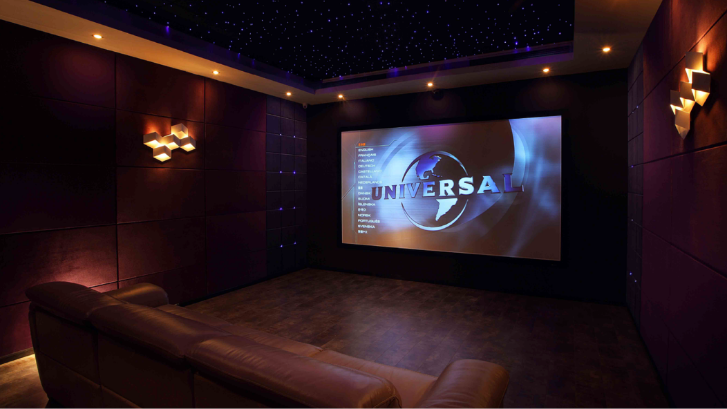 어둡고 작은 영화관, 스크린에 universal 로고가 띄워져 있다
