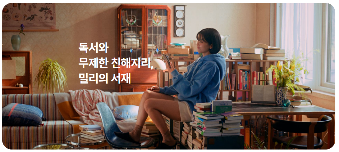 “독서와 무제한 친해지리, 밀리의 서재” 문구가 있는 이미지. 책과 가구로 가득한 방에서 여성이 독서를 즐기고 있음.